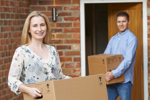 Movers carrying furniture down narrow Highbury staircase
